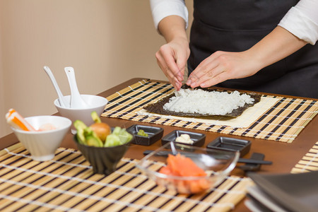 女厨师用手填满日本寿司卷在挪威图片