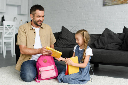 女儿和父亲在学校第一天上学时打包背回到图片