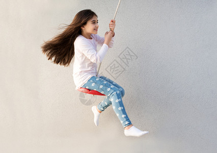 快乐的小女孩在秋千上玩耍背景图片