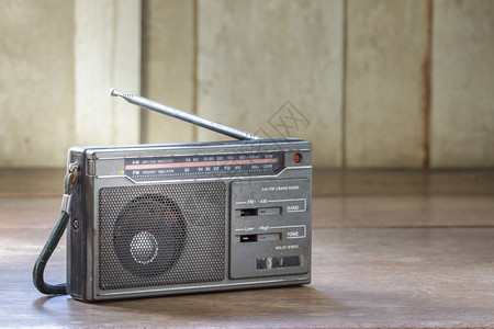 木制背景上的旧晶体管收音机图片