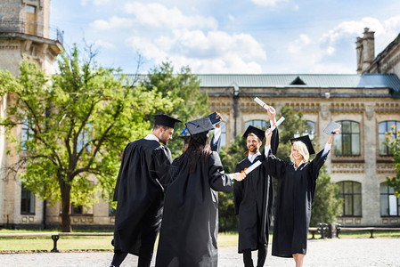 年轻的毕业学生在大学花园图片