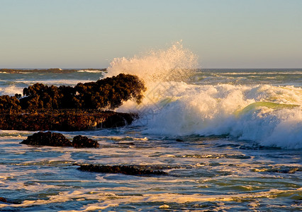 日落时海浪拍打岩石图片