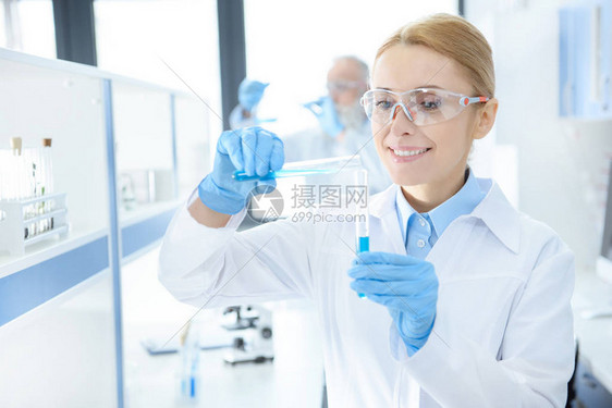 防护眼镜的专业科学家用试管中的试剂做实验图片