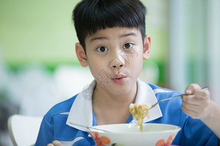 中餐坐在家里吃饭的年轻亚裔男孩背景