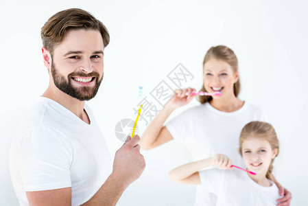 幸福的家庭用白色牙刷清洁牙齿的肖像图片