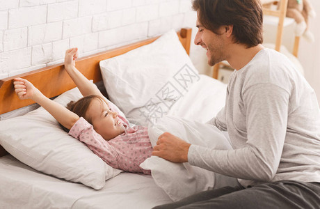 学龄前女孩醒来后在床上躺着向家里的图片