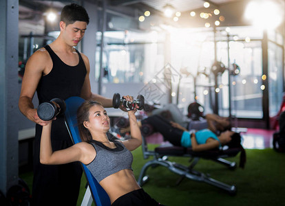亚洲教练和女士在健身俱乐部健康和健身理念中图片