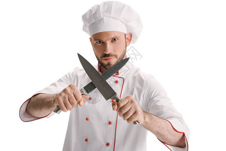 英俊的年轻厨师磨刀被白色隔离图片