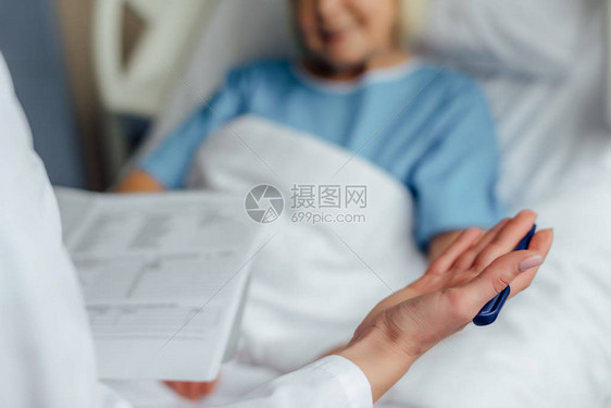 医生对躺在医院病床上的病人进行诊断和咨询的切图片