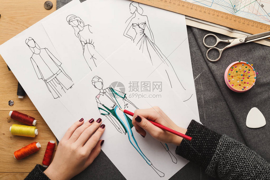 时装设计师在工作中的最高看法女手在她的创意工作区画衣服图片