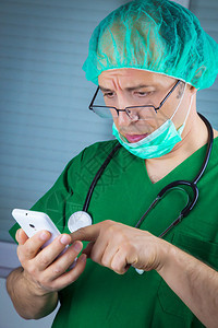 外科医生在手机上发信息口服绿色制服和图片