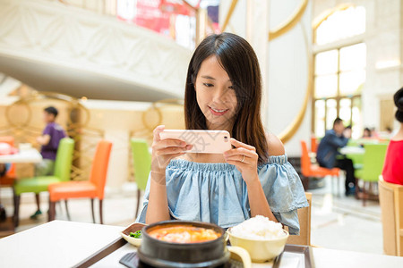 在餐厅的手机拍照的女人图片