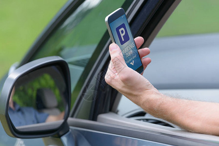司机使用智能手机应用程序在城市付费停车图片