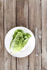 盘子上新鲜生菜沙拉的顶视图木桌上的餐具图片