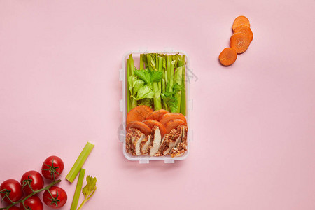 将健康的食物放在食物容器中以粉色隔离的图片