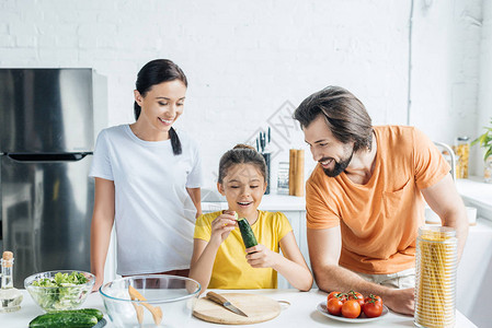 美丽的年轻家庭在一起烹饪健康晚餐图片