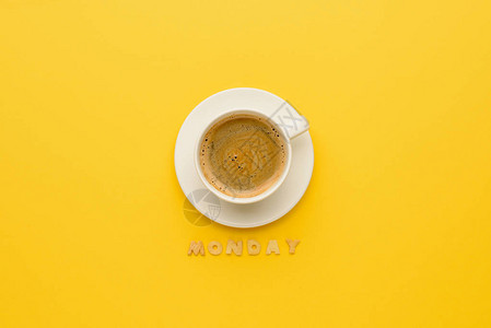 夹在黄色上的咖啡杯和星期一字图片