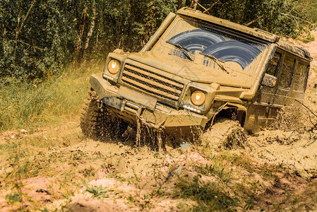 大越野车轮的底部视图与大型4x4车的旅行概念越野车上山从泥坑危险中背景图片