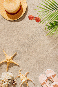 沙滩上戴着太阳镜和凉鞋的时尚帽子的顶视图图片