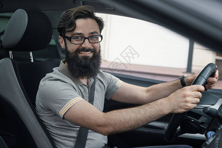我爱的车一个积极的大胡子男人微笑着驾驶他的汽车穿过城市每天享受简单的图片