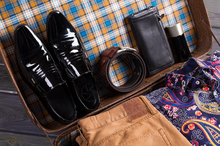男人的鞋子附件和衣服都装在旧手提箱里图片