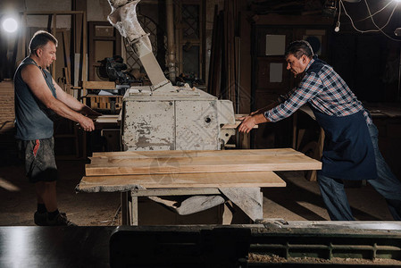 木匠在木工车间用木板工作图片