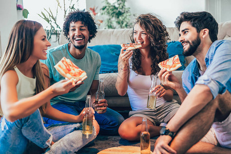 一群年轻朋友在家吃披萨和喝啤酒家图片