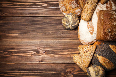 木制表面上的新鲜出炉的面包分类背景图片