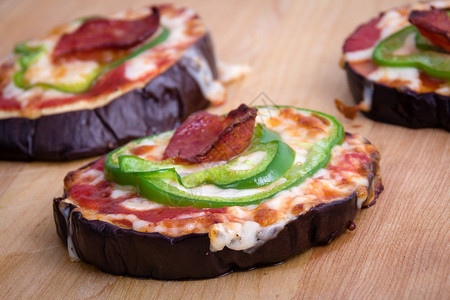 烤茄子片上的披萨作为餐桌上的披萨皮背景图片