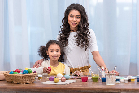 African美国母亲和女儿站在桌旁与东边的鸡蛋图片