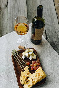 玻璃杯和白葡萄酒奶酪和葡萄的盘子图片