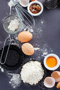 用于烘烤的成分和工具面粉鸡蛋和黑背景的滚图片