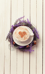 白色木制背景上的心形咖啡杯图片