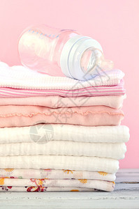 一堆折叠的粉红色婴儿衣物和尿图片