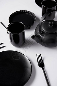 白色桌上黑茶壶盘子杯子叉子图片