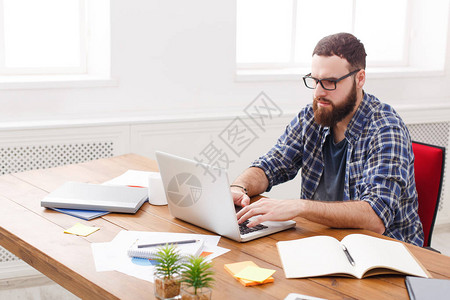 在现代白色办公室内部办公桌用笔记本电脑临时操作的年图片