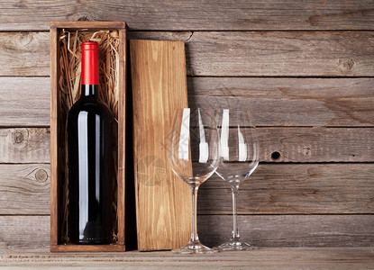 木墙前的红酒瓶和酒杯图片