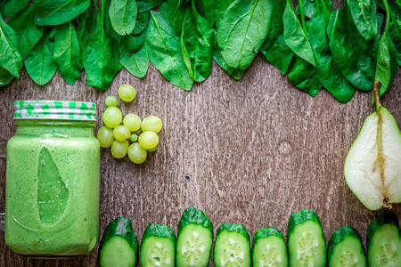 健康的绿色思慕雪与菠菜在一个杯子反对木制背景平躺与文本的地方素食和背景图片