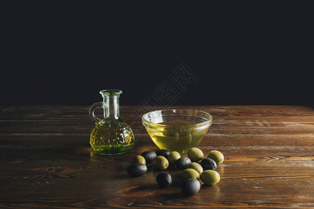 在木制桌上加橄榄油和橄榄图片