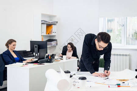 年轻男建筑师在一间宽敞的办公室里图片