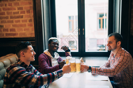一群快乐的年轻办公室员工在酒吧和啤酒交织在一起互相看图片