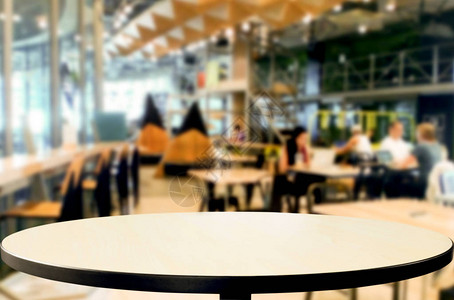 选中的空焦距棕色木制桌和咖啡店或餐馆背景模糊图片