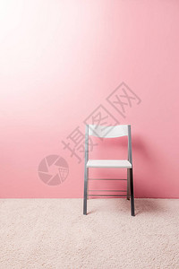 粉红色墙前的折叠椅图片