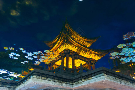 李江老城夜间池塘水中反映出风格的轻式光塔图片