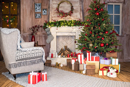 空的灰色扶手椅圣诞树下放着一堆礼盒背景图片