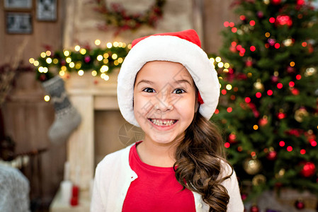 穿着圣诞老人帽子的小孩带着快乐的图片