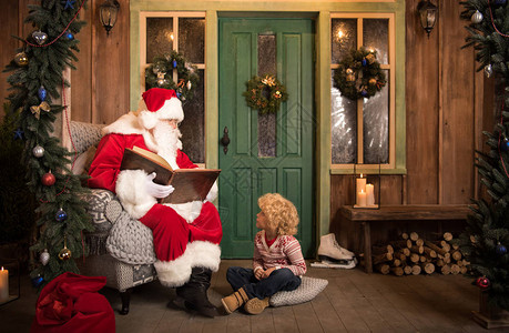 圣诞老人在圣诞节的时候给小孩读背景图片
