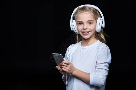 耳机中的小女孩听着从智能手机听到音乐图片