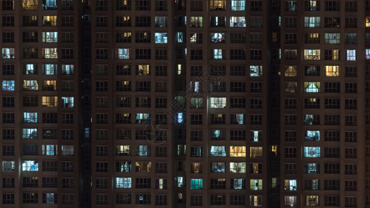 夜间多层公寓楼窗户的灯光图片