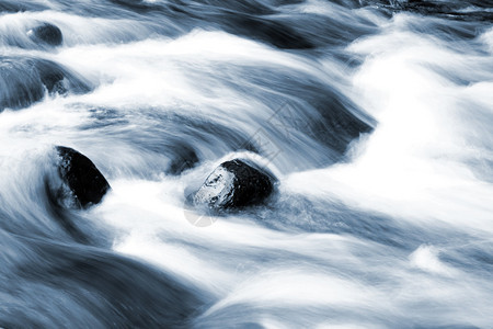 溪流在岩石上快速流动图片